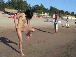 Nacktes Girl zeigt ihren Köper auf dem Strand